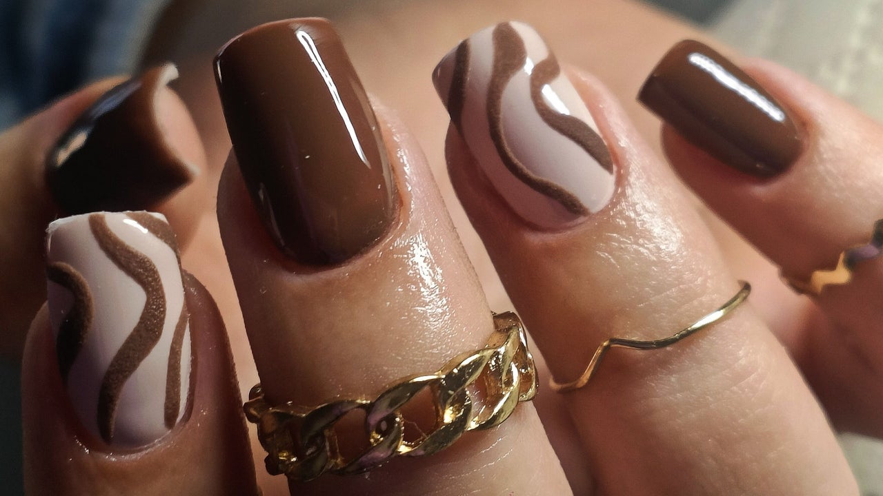 Chocoladebruine nagels met golvende swirl in nude, met een gouden schakelring