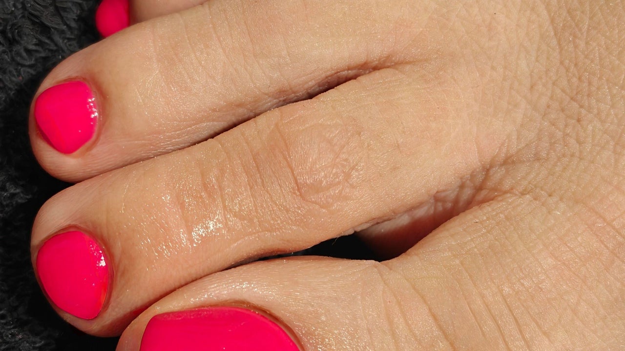 Close-up van teennagels in neonroze gellak