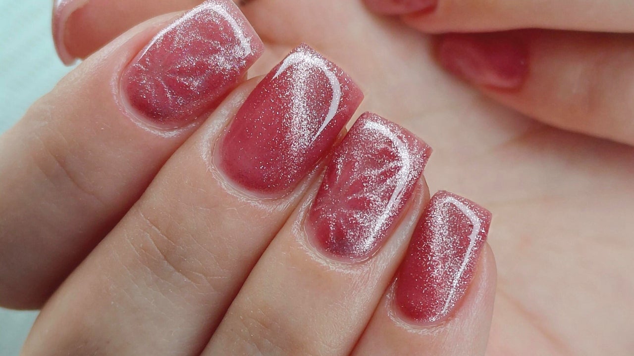 Roze cat-eye nagels met een witte swirl