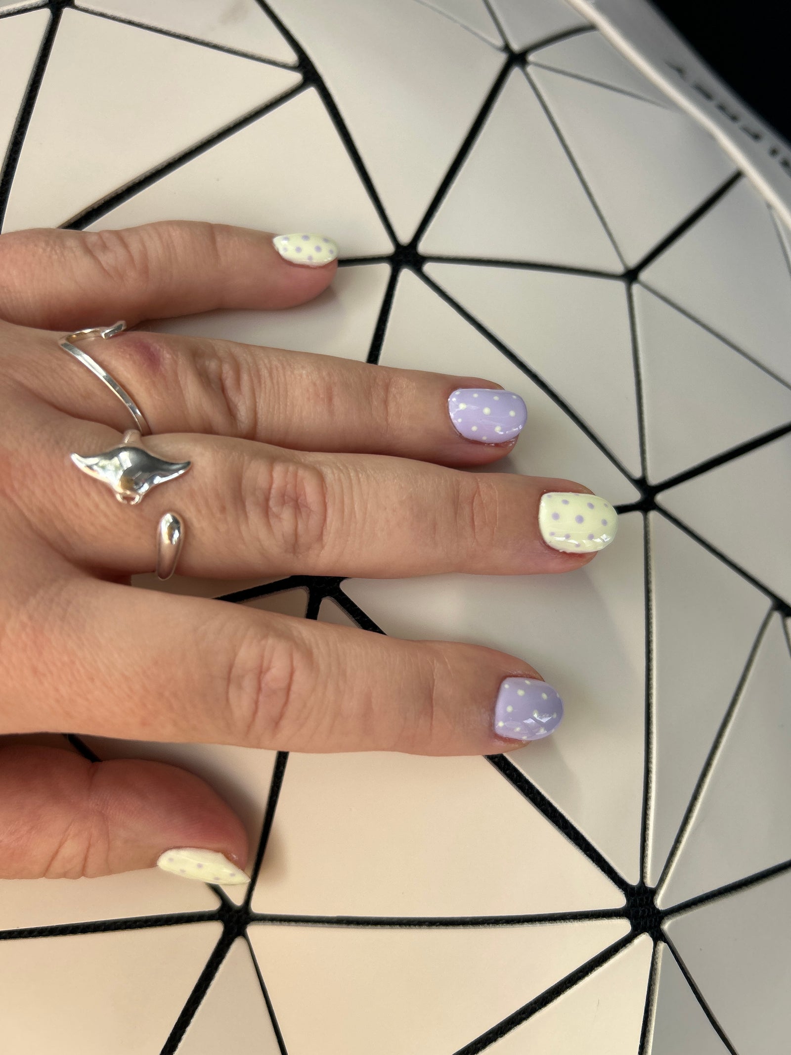 Korte nagels in pastel lila, geel en wit met stipjes, foto van een klant